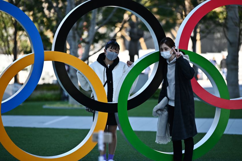 Personas con tapabocas posan con una exhibición de anillos olímpicos en Tokio. Foto: Charly Triballeau / AFP via Getty Images.