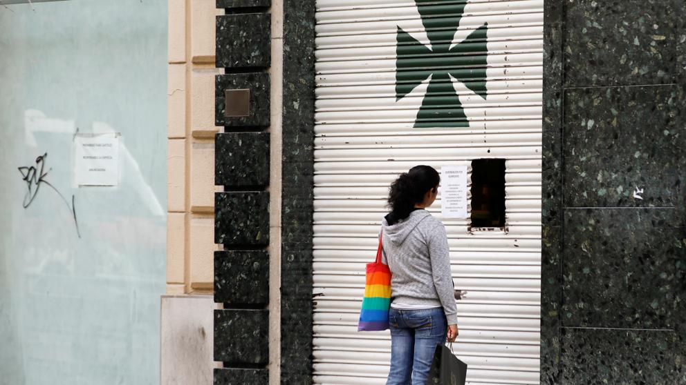 Una mujer espera ser atendida frente a una farmacia en Granada. Foto: Jon Nazca / Reuters.