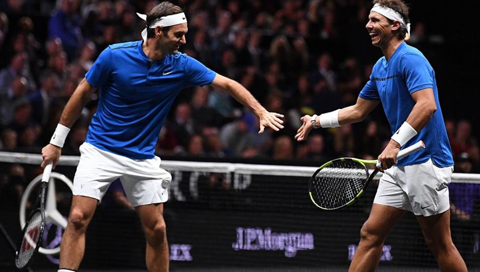 Roger Federer y Rafael Nadal a punto de chocar las manos en un partido de tenis