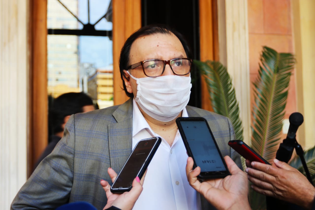 Titular del Banco Nacional de Fomento, Carlos Florentín, cubierto con tapabocas, hablando con la prensa.