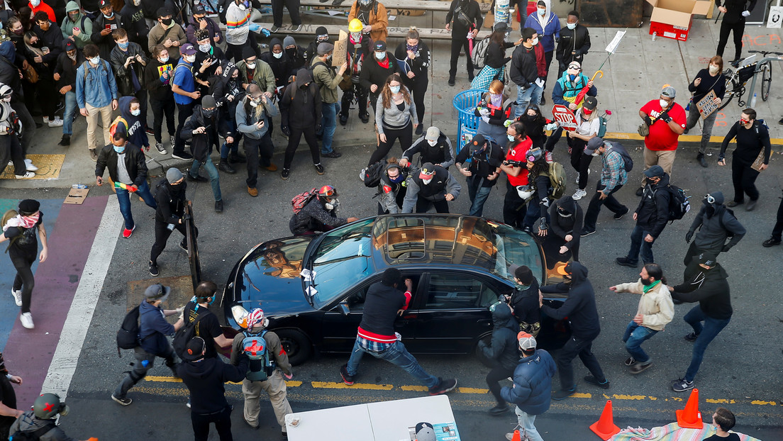 Momento en que el hombre avanzó hacia la multitud y los manifestantes intentan abrir su vehículo. Foto: Lindsey Wasson / Reuters