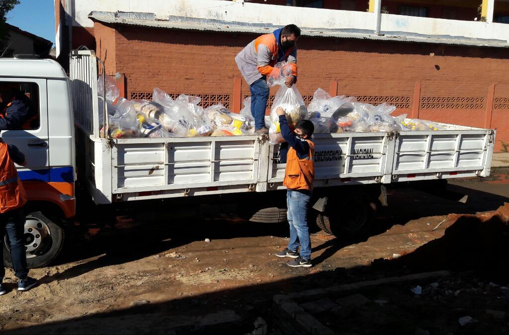 Camión de la SEN con kits de alimentos y dos funcionarios bajando del vehículo.