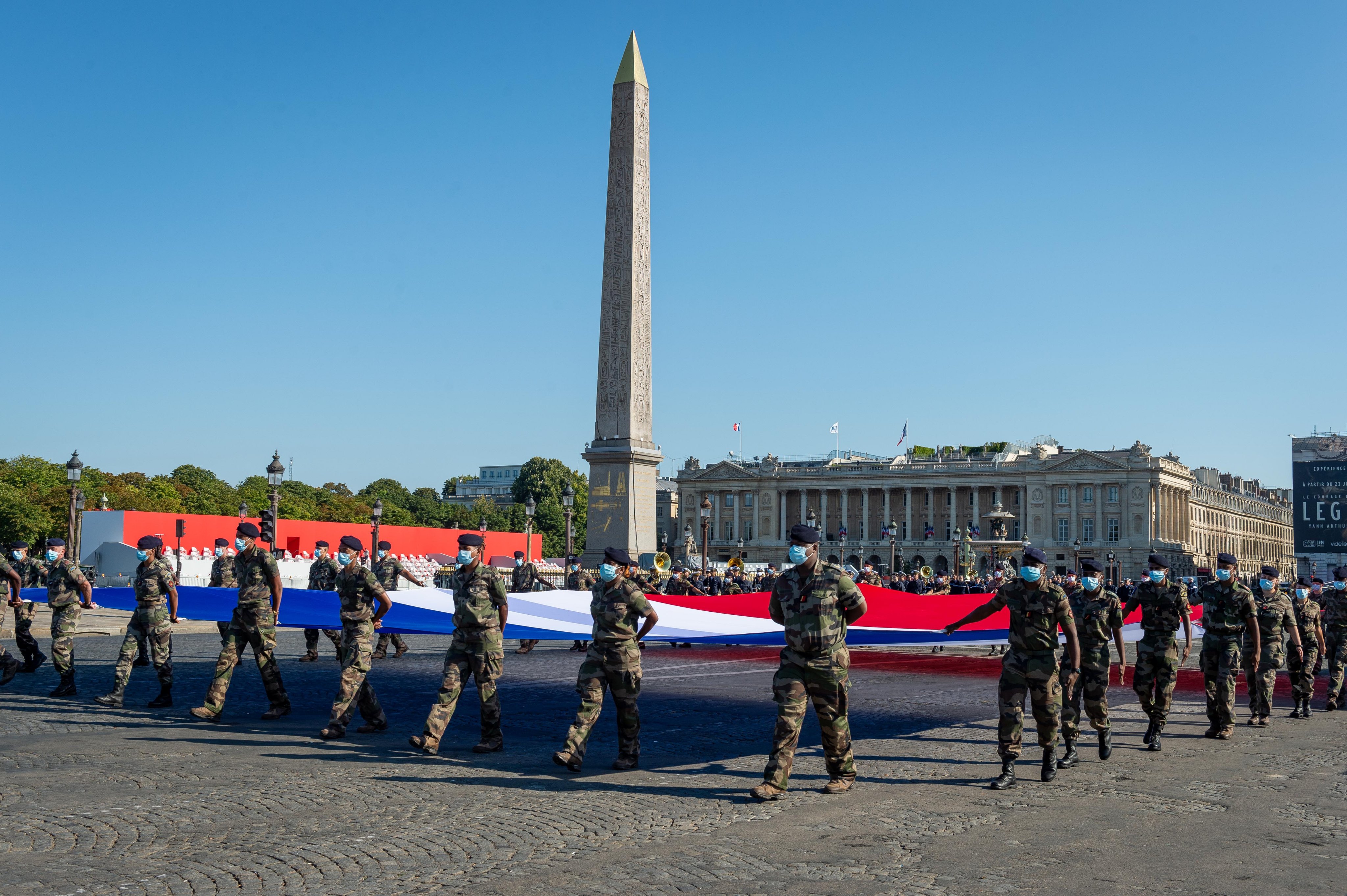 Militares desplegando la bandera francesa en la plaza de la Concordia en Paris.