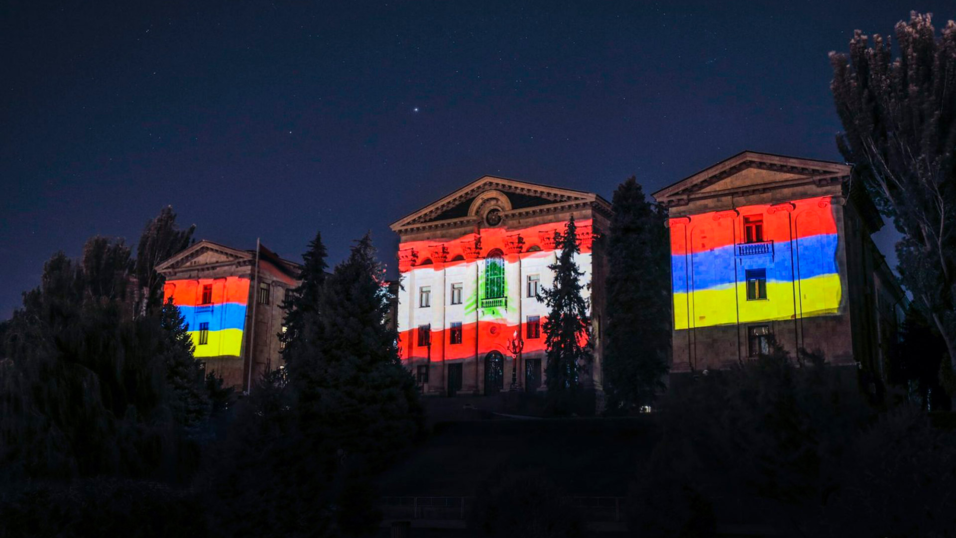 Edificio del Parlamento de Armenia con la proyección de la bandera del Líbano.
