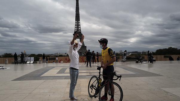 Ciudadanos frente a la Torre Eiffel con tapabocas.