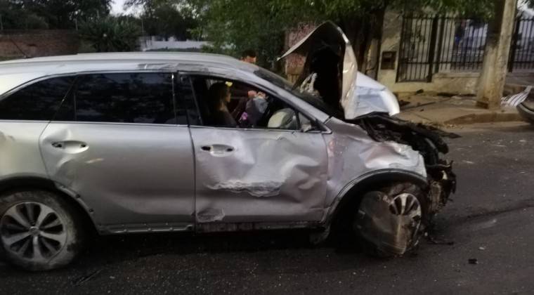 Camioneta con la conductora dentro de ella, abollada por el impacto.