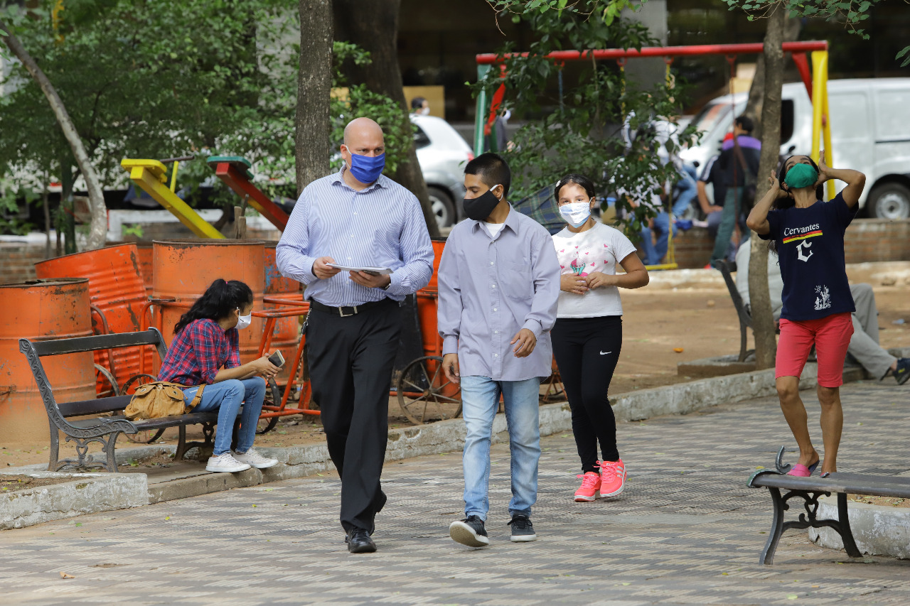 Personas caminando en la calle, con tapabocas.