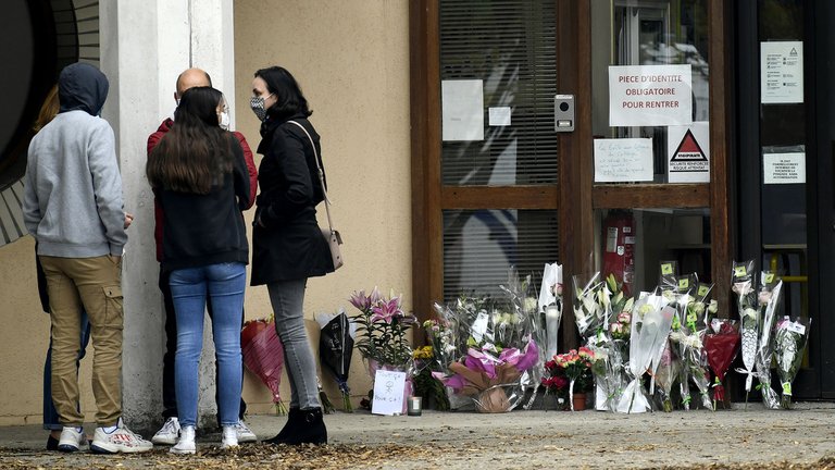 Varias personas dejaron flores en homenaje al profesor. Foto: Bertrand GUAY / AFP.