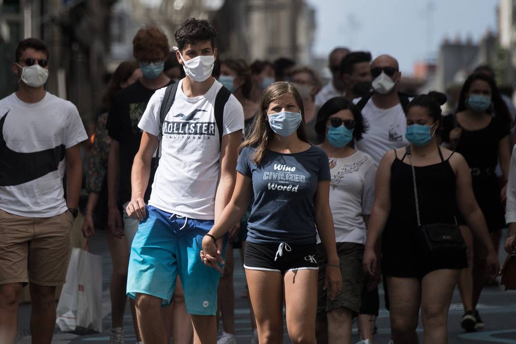 Personas caminando con tapabocas.