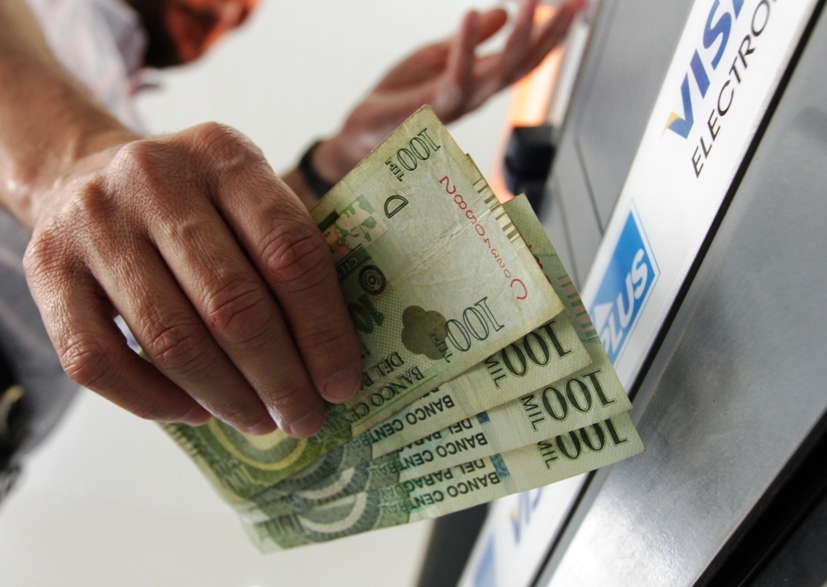 Cajero automático, billetes de cien mil.