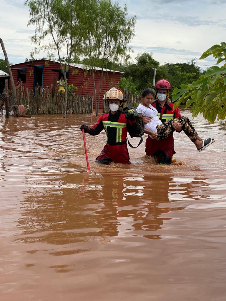 Bomberos Voluntarios, rescatando a una mujer que quedó atrapada en su casa. Foto: gentileza.